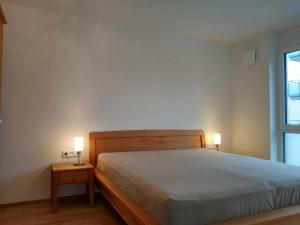 ein Schlafzimmer mit einem Bett und zwei Tischen mit Lampen in der Unterkunft Apartment "SUN" in Friedrichshafen