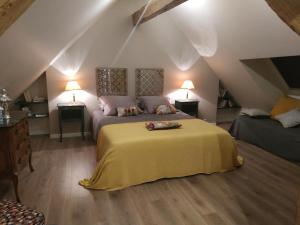 closerie des laudieres في Vineuil: غرفة نوم بسرير اصفر في العلية