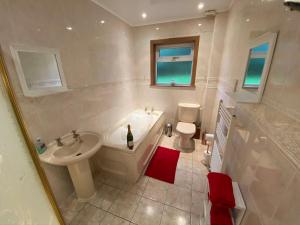 une salle de bain avec une baignoire, un lavabo et des toilettes dans l'établissement Country Cottage Sleeps 6 w Hot Tub & Dog-Friendly, à Moniaive 40 autres photos