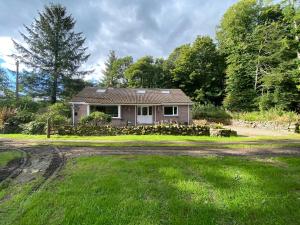 une petite maison sur un chemin de terre dans une cour dans l'établissement Country Cottage Sleeps 6 w Hot Tub & Dog-Friendly, à Moniaive