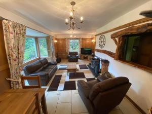 uma sala de estar com um sofá e uma mesa em Captivating Cottage with Hot Tub included Sleeps 6 em Moniaive