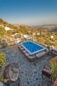 a swimming pool with two chairs and a table at Villa Anastasia in Voládha