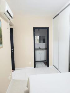 Habitación blanca con lavabo y espejo en Lindo Apto na Praia dos Ingleses, en Florianópolis