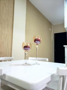 zwei Weingläser auf einem weißen Tisch in der Unterkunft Lindo Apto na Praia dos Ingleses in Florianópolis