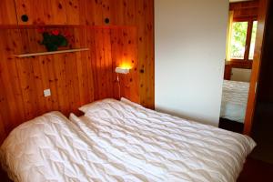 a bed in a bedroom with a wooden wall at Eanta SUNNY & MOUNTAIN chalet 10 pers by Alpvision Résidences in Veysonnaz