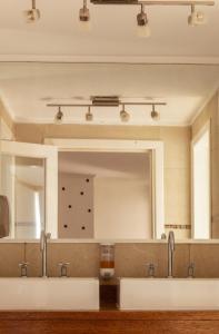 baño con 2 lavabos y espejo grande en Wood Side Hostel en Mar del Plata