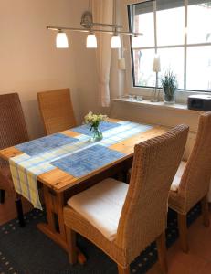 een eettafel met stoelen en een tafel met bloemen erop bij Haus Inge Ysker in Greetsiel