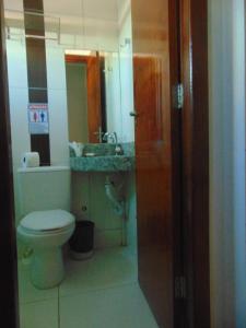 Łazienka z białą toaletą i umywalką w obiekcie CENTER PLAZA HOTEL w mieście Cristalina