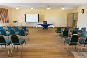 a room with chairs and a table and a screen at Days Inn by Wyndham Bonnyville in Bonnyville