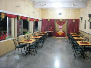 KhandwaHotel Grand Barrack的有长桌长椅的餐厅