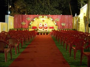 a row of chairs and a aisle with an altar at Hotel Grand Barrack in Khandwa