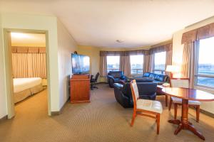 a hotel room with a couch and a table at Days Inn by Wyndham Bonnyville in Bonnyville +35 photos