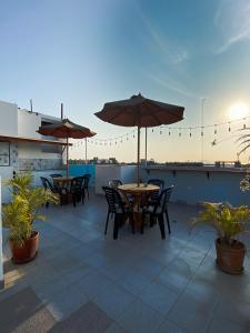 eine Terrasse mit Tischen und Sonnenschirmen auf dem Dach in der Unterkunft Tupac Lima Airport in Lima