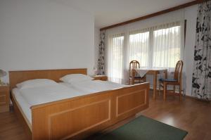 ein Schlafzimmer mit einem großen Bett, einem Tisch und Stühlen in der Unterkunft Gästehaus Pension Edelweiss in Kolsass