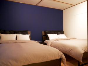 um quarto com 2 camas e uma parede azul em Mansion Daini Shiratori - Vacation STAY 9657 em Osaka