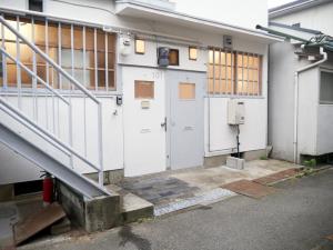 um edifício com duas portas brancas e uma escada em Mansion Daini Shiratori - Vacation STAY 9657 em Osaka