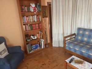 ein Wohnzimmer mit einem Sofa und einem Bücherregal mit Büchern in der Unterkunft La cerca de la Mata, decerca in Arcones
