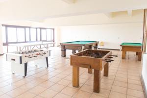uma sala com três mesas e mesas de bilhar em Hotel Araçá em Capão da Canoa