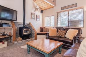 Una sala de estar con un sofá y una estufa de leña. en Bigwood W #90, en Mammoth Lakes