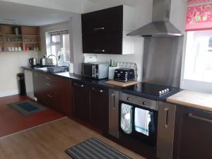 a kitchen with a black counter top with a stove at Bryncarnedd Farmhouse in Aberystwyth