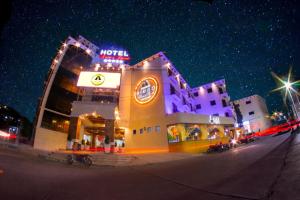 un edificio de hotel con un cartel en él por la noche en Hotel Ruinas Resort, en Huehuetenango