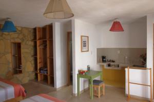 a room with a bed and a table and a kitchen at Gaia Guest House in San Cristóbal de Las Casas