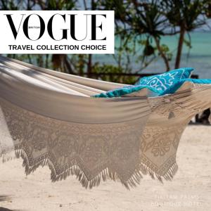 a hammock on a beach with the words vogue travel collection choice at Tikitam Palms Boutique Hotel in Pongwe