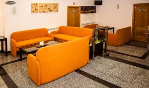 a waiting room with orange chairs and a table at Hotel Restaurante Xaneiro in Melide