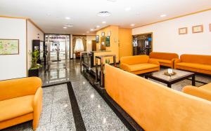 a waiting room with orange couches and a table at Hotel Restaurante Xaneiro in Melide