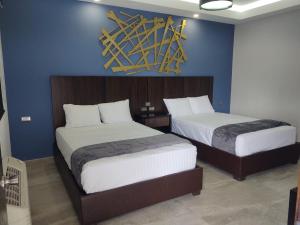 sypialnia z 2 łóżkami i niebieską ścianą w obiekcie SAND MAR HOTEL w mieście Puerto Peñasco
