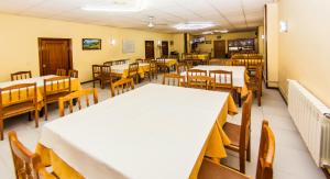a dining room with tables and wooden chairs at Hotel Restaurante Xaneiro in Melide