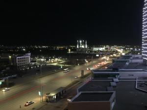 a city street at night with cars and buildings at Квартира в 11 микрорайоне, жк. Арай in Aktobe