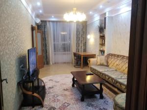sala de estar con sofá y mesa en Квартира в 11 микрорайоне, жк. Арай, en Aktobe