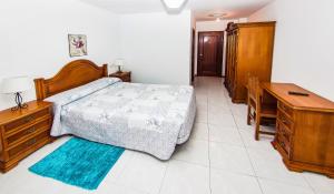 a bedroom with a bed and a dresser and a desk at Hotel Restaurante Xaneiro in Melide