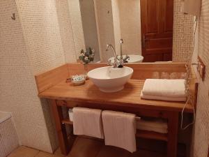
a bathroom with a sink and a towel rack at Hotel Rural El Rexacu in Bobia de Arriba
