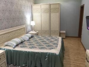 1 dormitorio con 1 cama grande y cabecero grande en Квартира в 11 микрорайоне, жк. Арай, en Aktobe