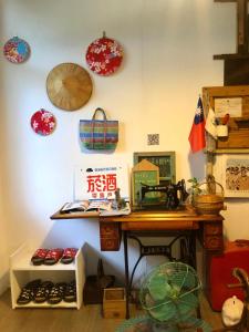 a room with a wooden desk and plates on the wall at Meo-Woo Cat Travel b&b in Sanzhi