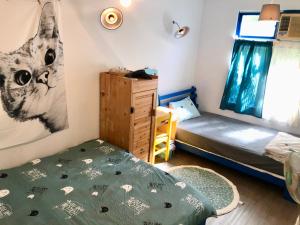 Schlafzimmer mit einem Bett, einem Schreibtisch und einem Fenster in der Unterkunft Meo-Woo Cat Travel b&b in Sanzhi