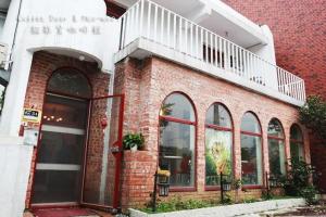a brick building with a balcony on top of it at Meo-Woo Cat Travel b&b in Sanzhi