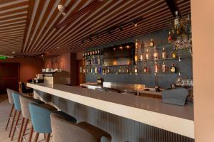 a bar with chairs and a counter with alcohol bottles at Hotel Puerto Pacifico Guayaquil Airport in Guayaquil