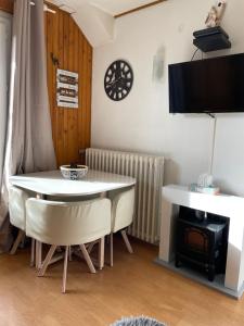a living room with a table and chairs and a fireplace at Appartement RDC "Chez Marmotte" avec terrasse, 5 personnes, Font Romeu in Font-Romeu-Odeillo-Via