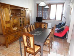 ein Esszimmer mit einem Tisch, Stühlen und einem Sofa in der Unterkunft L'estaou in Lavoûte-Chilhac