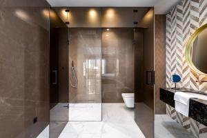 a bathroom with a shower and a toilet and a sink at Lure Hotel & Spa - Adults Only in Mellieħa