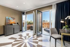 a living room with a desk and a room with glass doors at Lure Hotel & Spa - Adults Only in Mellieħa