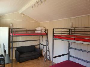 two bunk beds in a room with a chair at Bratland Camping in Bergen