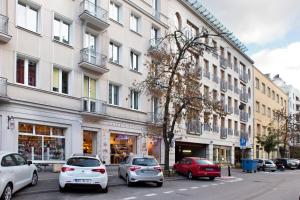 a street with cars parked in front of buildings at Poznanska Serviced Apartments in Warsaw