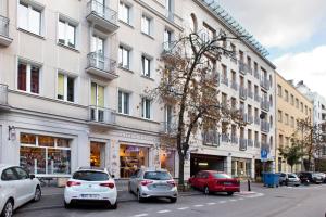 a street with cars parked in front of buildings at Plater & Poznanska Serviced Apartments in Warsaw