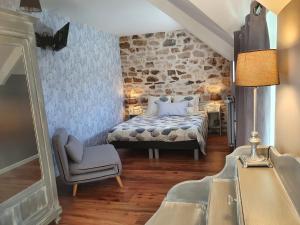 a bedroom with a bed and a chair at Graine de Reves in Saint-Sauveur-la-Pommeraye