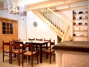 a dining room with a table and chairs and a staircase at Casa Eva Wagner - Biertan in Biertan
