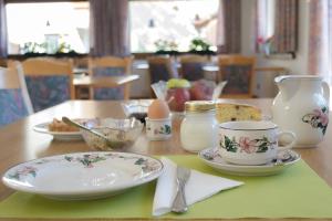 un tavolo con piatto, tazza e piattino di Meublè Rosalpina a Valdidentro